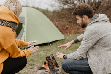 Personen zelten am Lagerfeuer